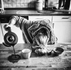 black and white photograph of a woman with her head down on the floor next to cupcakes