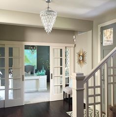 a chandelier hanging from the ceiling in a living room next to a door