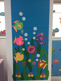 a door decorated with fish and seaweed on a blue background in an office cubicle