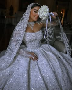 a woman in a white wedding gown holding a flower