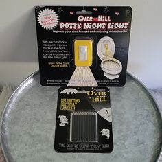 a metal tray with a white light on it and a card attached to the lid