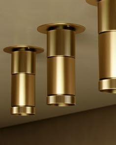 three gold colored lights hanging from the ceiling