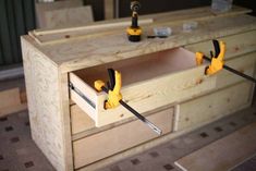 two pliers are being used to attach the drawers in this workbench cabinet