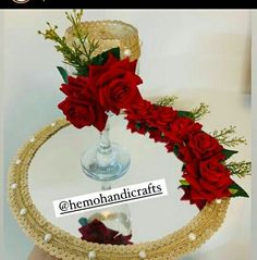 there is a cake with red roses on it and pearls around the edges, as well as a candle holder