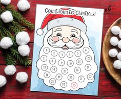 a calendar with santa claus on it next to some cotton balls and a bowl of candy