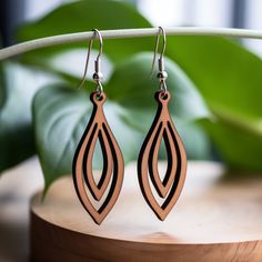 the earrings are made from wood and have an intricate design