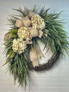 a wreath with flowers and greenery hanging on the wall