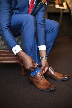 a man in a suit tying his shoes