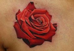 a rose tattoo on the back of a woman's shoulder