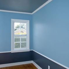 an empty room with blue walls and white trim