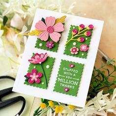 a card with flowers on it sitting next to some scissors and other crafting supplies