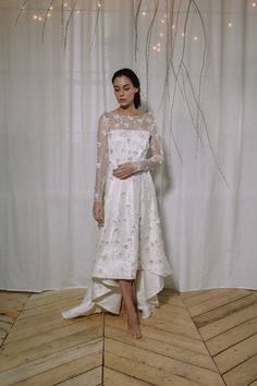 a woman standing in front of a white curtain