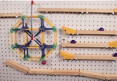 several wooden pegs are attached to the wall with magnets and balls on them