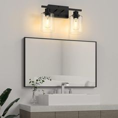 a bathroom vanity with two lights above it and a mirror on the wall next to it