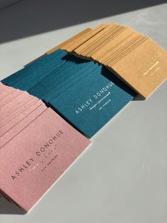 three folded business cards sitting on top of each other in front of a white table