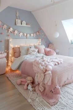 a bedroom decorated in pink and white with lights on the ceiling, teddy bear bedding