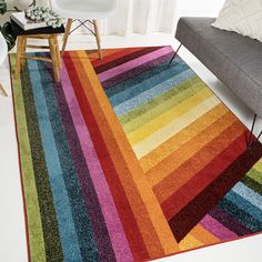 a multicolored area rug in a living room with a couch and chair next to it