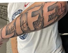 a man with a tattoo on his arm that reads fifty five and the words fifty seven are in cursive font