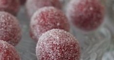 there are many red balls covered in powdered sugar on the glass plate and ready to be eaten