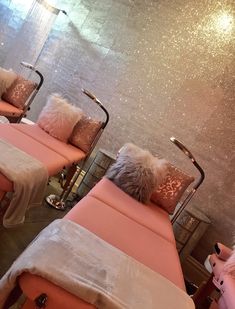 some pink chairs with pillows and blankets on them in a room filled with glitter walls