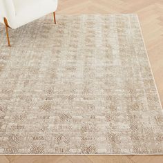 a white chair sitting on top of a wooden floor next to a beige area rug