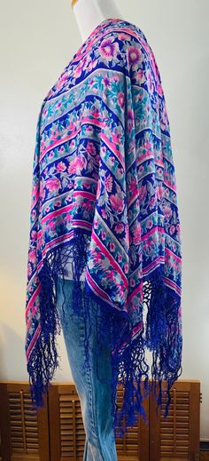 "Very Daisy Jones, here is a vintage shawl/scarf, purple with pink flowers and gray accents. Very delicate 100% pure silk with hand knotted purple fringe all around. Measures 36\" in diameter. PLEASE NOTE: This pretty vintage scarf does have some minor pinholes and one area where it has been mended, see photos. Still too beautiful to discard. Wear it as a wrap, drape it over a chair or table, many uses. Very cool." Bohemian Silk Shawl With Floral Print, Bohemian Silk Floral Print Shawl, Floral Print Shawl Scarf, One Size Silk Shawl Scarf For Spring, Floral Print Shawl Scarf One Size, Spring Silk Shawl Scarf, Pink Bohemian Shawl For Spring, One Size Floral Print Shawl Scarf, Pink Shawl Scarf For Spring