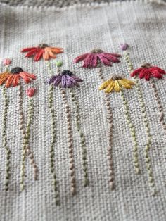 a close up of a piece of cloth with flowers on it and thread in the middle