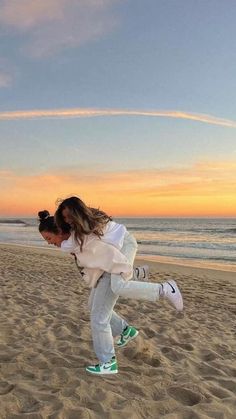 a girl is running on the beach at sunset with her hair blowing in the wind