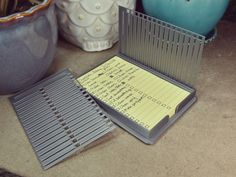 a notepad and pen sitting on top of a table next to vases with flowers