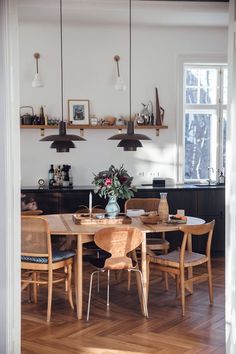 a dining room table and chairs in front of a window