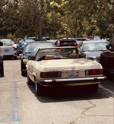 an old car is parked in a parking lot