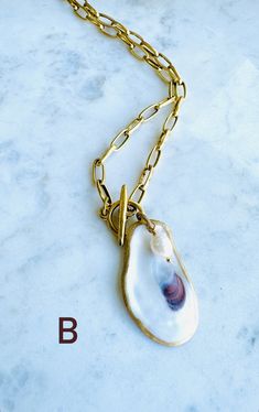 A truly One-of-a-Kind statement piece. Hand painted gold leaf natural oyster shell pendants with gorgeous freshwater pearls, on high quality 12K Gold over brass chain with toggle front closures. Each shell has been harvested in our Charleston, SC rivers and are carefully hand finished to create its one-of-a-kind appearance. No two shells are alike. Each oyster shell has its own story behind its journey to the shore. The size, shape and colors in each one will vary and that is what makes each she Oyster Shell Necklace, Journey To The Shore, Oyster Ideas, Horse Unique, Ocean Jewelry, Oyster Shells, Shell Jewelry, Oyster Shell, Shell Crafts