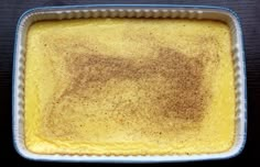 a casserole dish with some brown stuff in the bottom and yellow liquid on top