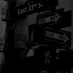 black and white photograph of street signs in front of an east 33rd st apartment building