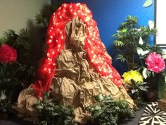 there is a fake mountain made out of paper and lights in the middle of some potted plants