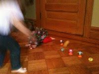 blurry image of a person playing with toys on the floor in front of a door