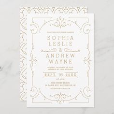 a white and gold wedding card with an ornate design on the front, featuring a golden border