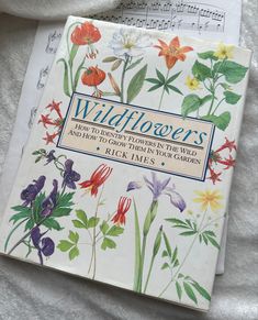 the book wildflowers is laying on top of sheet music