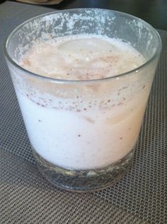 a glass filled with liquid sitting on top of a table