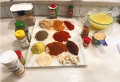 spices and seasonings are arranged on a cutting board in the middle of a kitchen counter