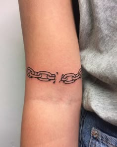 a woman's arm with a tattoo on it that has two chains attached to it