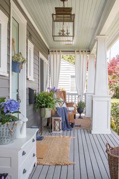 the front porch is decorated with blue flowers and wicker baskets on it's sides