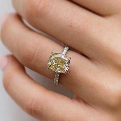 a woman's hand with a yellow and white diamond ring