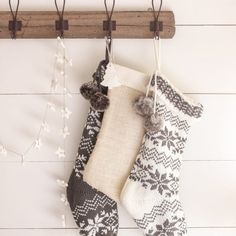 two christmas stockings hanging from hooks on a wall