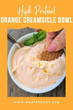 a bowl filled with orange creamsice and topped with waffle crackers, garnished with basil leaves