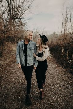 a man and woman walking down a dirt road