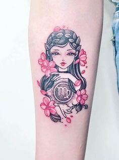 a woman's arm with a tattoo on it that has pink flowers around her