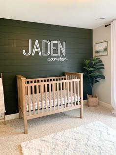 a baby's crib in the corner of a room with green painted walls