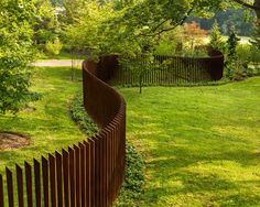 a metal fence in the middle of a grassy area