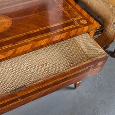 an old wooden table with woven seat padding